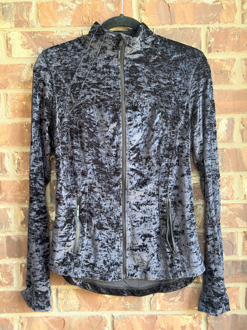 Lululemon women's full-zip athletic jacket in a dark charcoal gray/black crushed velvet fabric. Features a fitted silhouette, high neckline, full front zipper, zippered hand pockets, long sleeves with thumbholes, curved high-low hem and reflective Lululemon logo at the upper back.

Size: 12
Color: Charcoal Gray / Black
Style: Full-Zip Athletic Jacket

Beautiful crushed velvet texture gives this jacket a more elevated look than a traditional workout jacket.

Pre-owned condition. Please review all photos care